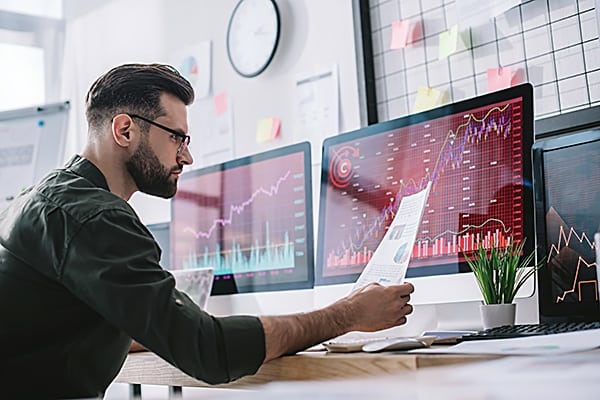 Side view of information security analyst looking at charts near